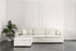 White sectional sofa bed in a room with a plant and decorative wall.