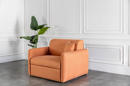 Orange comeover armchair sofa bed in a room with white paneled walls and a plant